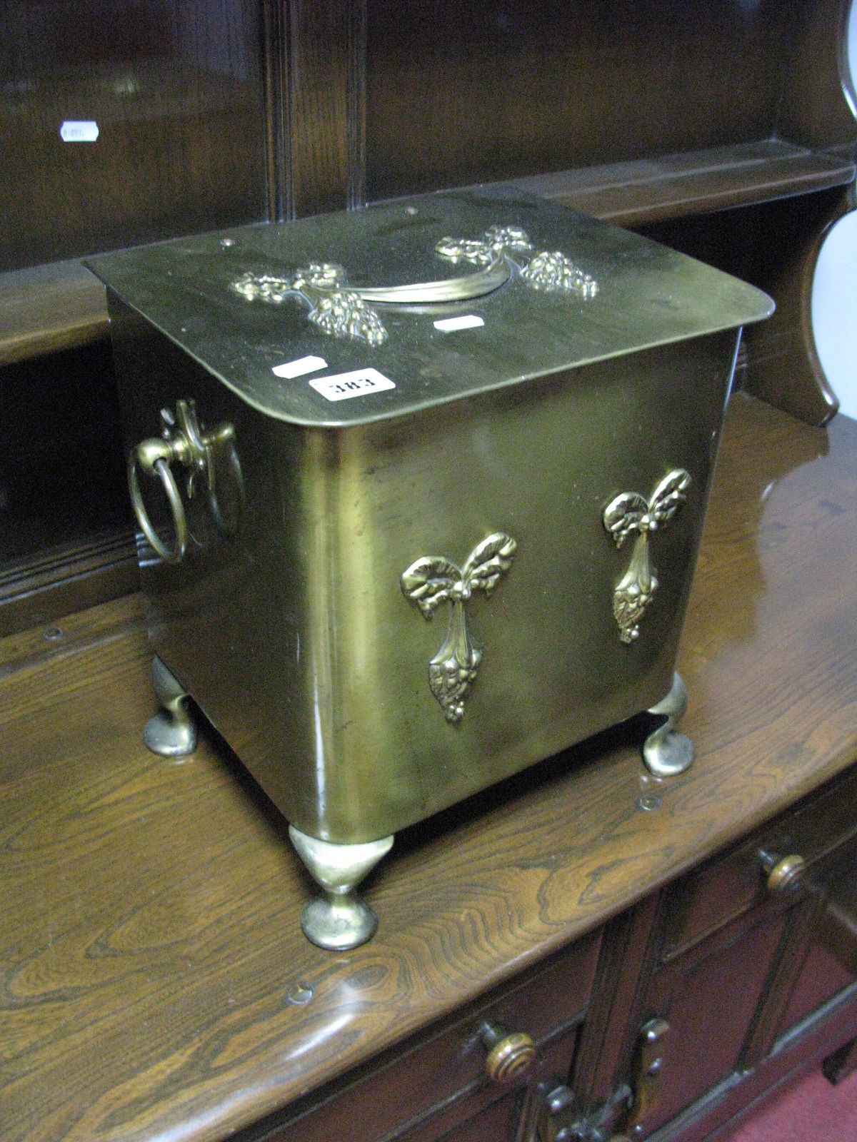 An Early XX Century Brass Coal Box, hinged lid with swag decoration, twin loop carrying handles on