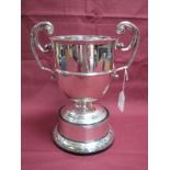 A Hallmarked Silver Twin Handled Trophy Cup, marks rubbed, of plain circular form, between twin leaf