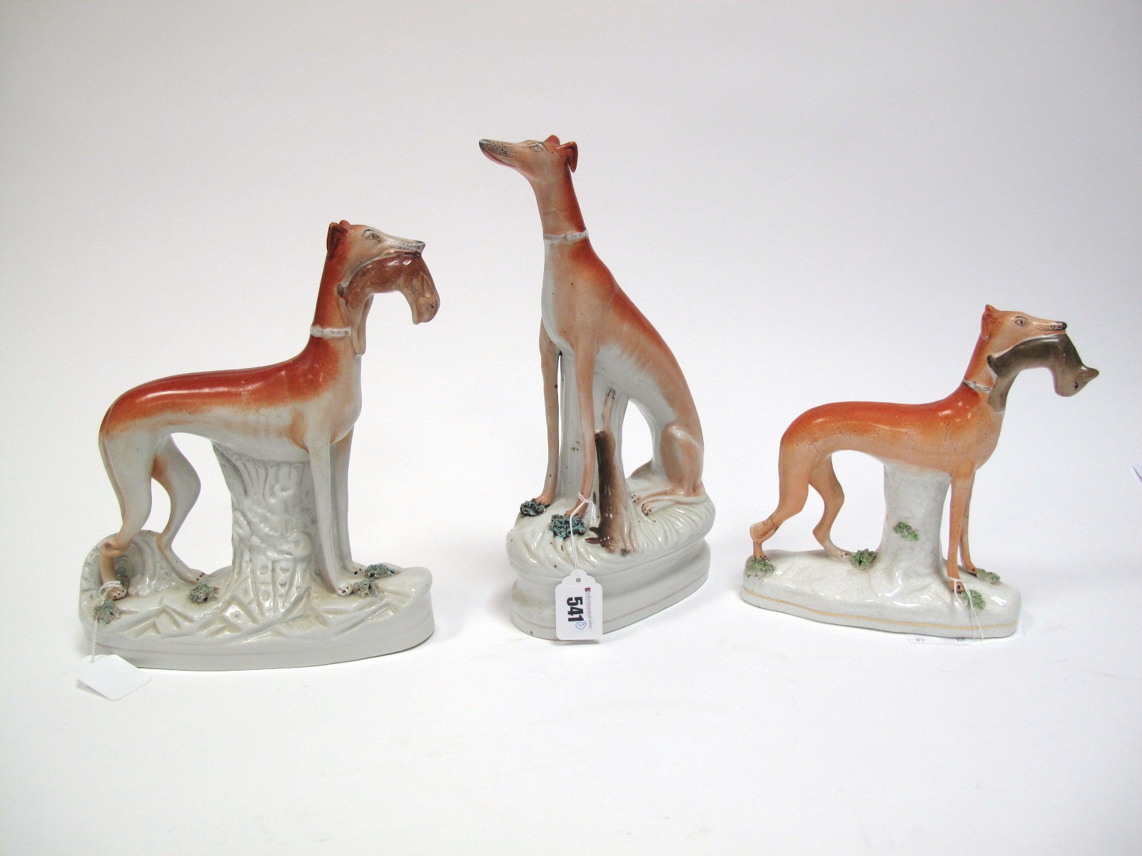 A XIX Century Staffordshire Pottery Greyhound Dog, hind legs squatting, with game by its side, on