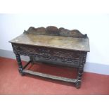 A XVII Century and Later Oak Side Table, with a shaped low back, carved top, carved dummy drawer