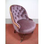 A XIX Century Walnut Nursing Chair, with hooped back and upholstered in purple velvet, on cabriole