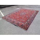 A Mid XX Century Afghan Carpet, the madder field with an intense allover pattern of flowers (