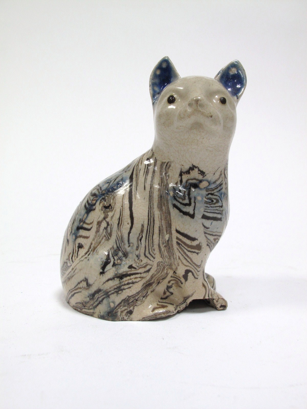 An XVIII Century Staffordshire Pottery Agate Ware Model of a Seated Cat, (area of loss to base rim),