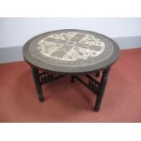 An Early XX Century Indian Table, the circular brass top with chased floral decoration and central