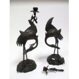 A Pair of Late XIX Century Japanese Cast Bronze Candlesticks, each as a crane holding a lotus branch