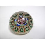 A XIX Century Paperweight, with radiating filigree canes around two concentric rows of floret canes,