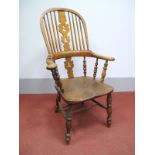 A XIX Century Elm Windsor Chair, with hoop back, christmas tree splat and broad pad arm, shaped