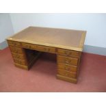 An Early XX Century Oak Pedestal Desk, with crossbanded top and leatherette scriver, three top