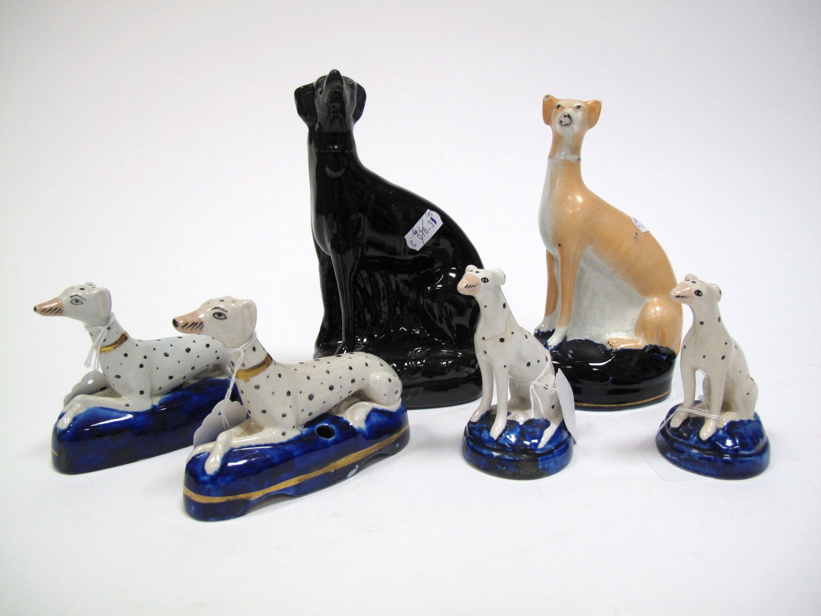 A XIX Century Staffordshire Pottery Greyhound, squatting on hind legs, on blue oval base, 17.5cms;