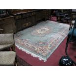 A Chinese Wool Rectangular Rug, with tassle ends, floral and foliate motifs on a green ground, 350 x