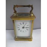 An Early XX Century French Brass Carriage Clock, with an enamel dial and Roman numerals.