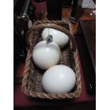 Three Ostrich Eggs, contained within a wicker basket.