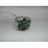 A Modern 18ct White Gold Emerald and Diamond Cluster Ring, of flowerhead design, complete with