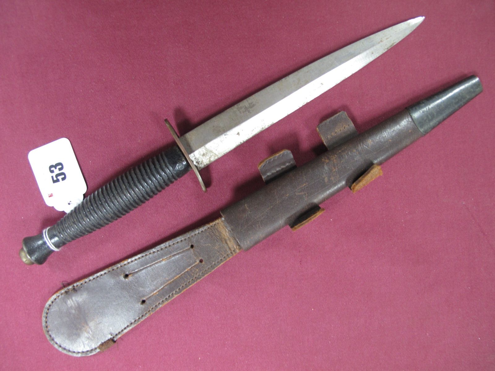 A Fairbairn-Sykes Fighting Knife, double sided 17cms blade, polished. Blackened brass grip, complete