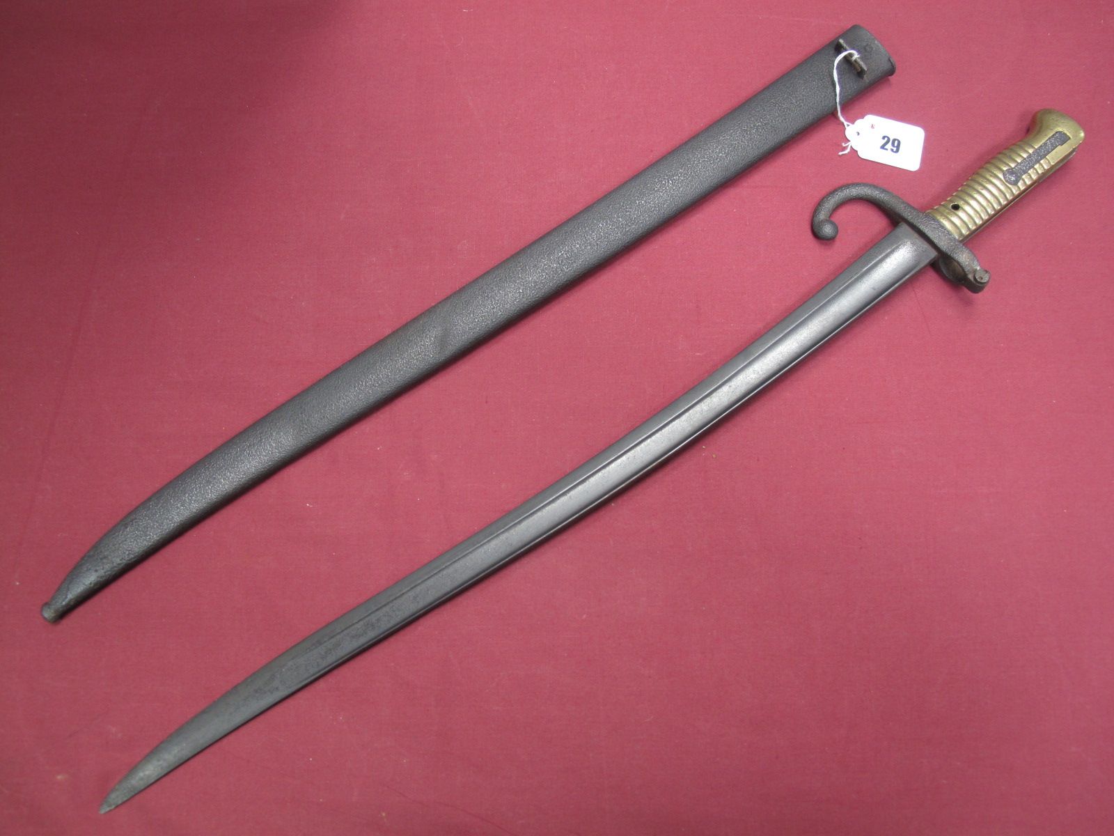 A XIX Century French Sabre Bayonet, ribbed brass grip, spring catch operative. Pitting and wear.