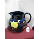 Moorcroft Pottery Jug, with yellow and red fruit with leaves design on a blue ground, painted