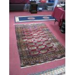 A Middle Eastern Rug, early to mid XX Century, with twenty-seven large central motifs on red ground,