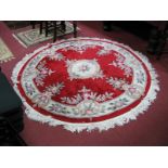 A Chinese Circular Tasseled Wool Rug, with allover floral motifs on red ground and cream border,