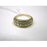 A Two Row Diamond Set Dress Ring, of uniform design, millegrain set, between bifurcated shoulders,