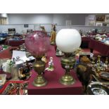 Two Brass Oil lamps with Funnels, one with cranberry glass shade, the other white.