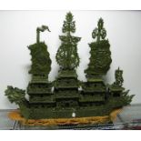 A Large Oriental Green Hardstone Dragon Junk Boat, decorated with pagodas, dragons and banners,