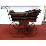 A Victorian Pram, the wood framed body with padded leather cloth interior, folding hood, sprung base