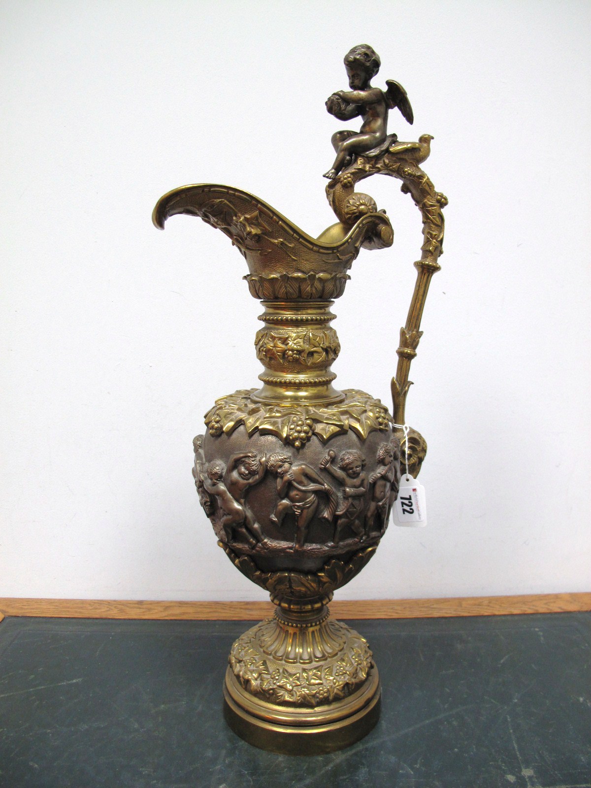 A Continental Bronze Ewer, heavily cast in relief with bands of carousing cherubs and fruiting