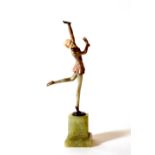 An Art Deco coloured bronze figure of a lady dancing, with her hands held aloft, raised on green
