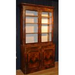 A Victorian rosewood bookcase, the top with moulded cornice above two glazed doors enclosing shelved