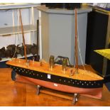 A home built painted wood model pond boat, decorated with brass funnels and wooden masts, raised