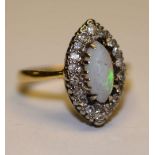 An 18ct gold and platinum opal and diamond dress ring, the central opal surmounted by 18 round cut