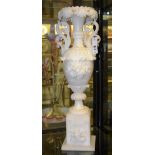 A twin handled alabaster vase, possibly Italian, carved with vines and foliate decoration, raised on