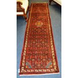 An Eastern runner, the central medallion over red ground with allover floral design and border,