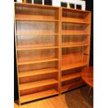 A pair of tall modern open bookcases, en