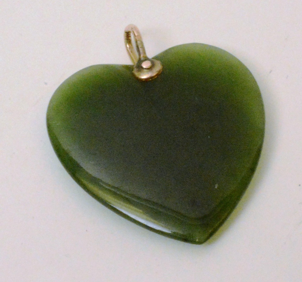 A yellow metal and jade style heart shap