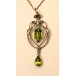 A yellow metal peridot and diamond pendant, the central emerald cut peridot drop (approx. 1.5ct)