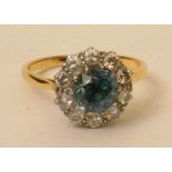 A yellow metal blue zircon and diamond flowerhead ring, the central blue topaz surrounded by 10
