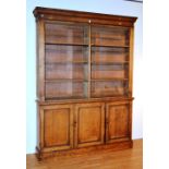 A Victorian oak library bookcase, with moulded cornice above open shelves and three panelled doors