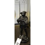 A Russian ebonised cast metal figure of a boy, with fishing rod, raised on circular base, makers