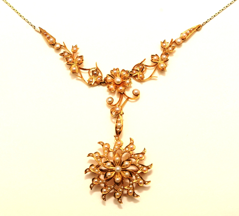 A late Victorian 15ct gold and seed pearl pendant, the central flowerhead drop and foliate detail