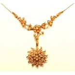 A late Victorian 15ct gold and seed pearl pendant, the central flowerhead drop and foliate detail