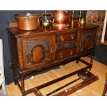 A 1940's carved oak sideboard, with two drawers flanked by carved panelled door,