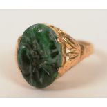 A 22ct gold Oriental jade ring, with lotus flower carved to jade and foliate gold decoration to