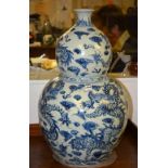 A large Chinese blue and white double gourd vase, with five claw dragon decoration on a white