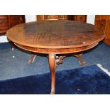 A figured walnut circular dining table, in the Victorian style,