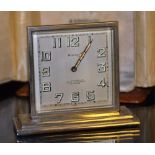 An Art Deco silver plated 8-day travel clock by A L'Emeraude,