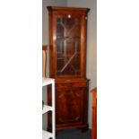 A reproduction corner cabinet, with glazed astragal door enclosing shelves interior,