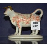 A 19th century Staffordshire cow creamer, with orange and black sponged decoration to body,