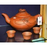 A Japanese Teracotta saki teapot, with grotesque mask finial and relief decoration,