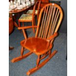 A modern hardwood rocking chair, with hoop back and spindle supports, solid seat,